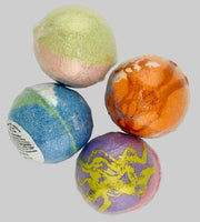 Four colorful bath bombs on a light gray background