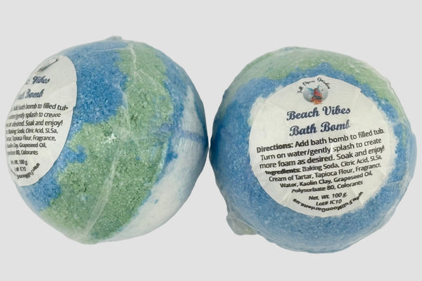 Two beach-themed bath bombs with labels on a white background