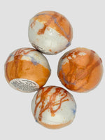 Four marbled bath bombs on a light gray background