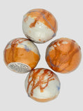 Four marbled bath bombs on a light gray background