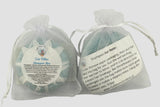 Two Full Moon Gardens shampoo bars in white organza gift bags with labels on a light gray background